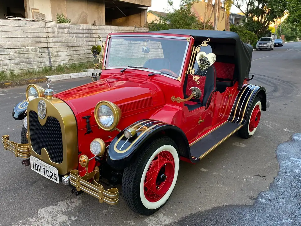 Calhambeque vermelho e preto com detalhes dourados e pneus de faixa branca