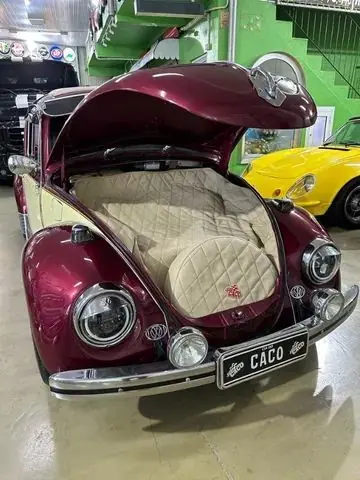 Frente do Fusca vinho com o porta-malas aberto, forrado em matelassê creme