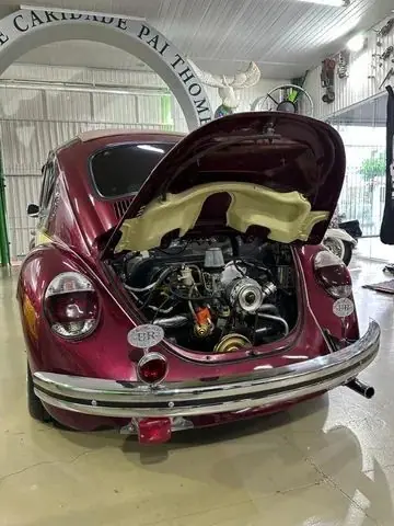 Fusca vinho com a tampa do motor aberta