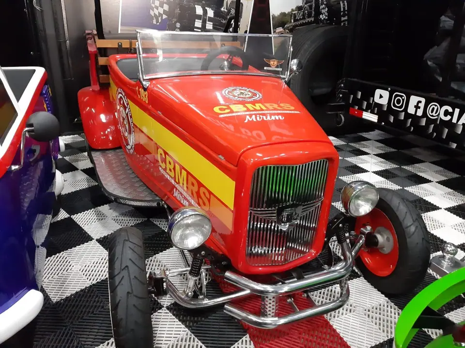 Mini carro vermelho e amarelo com emblema do CBMRS