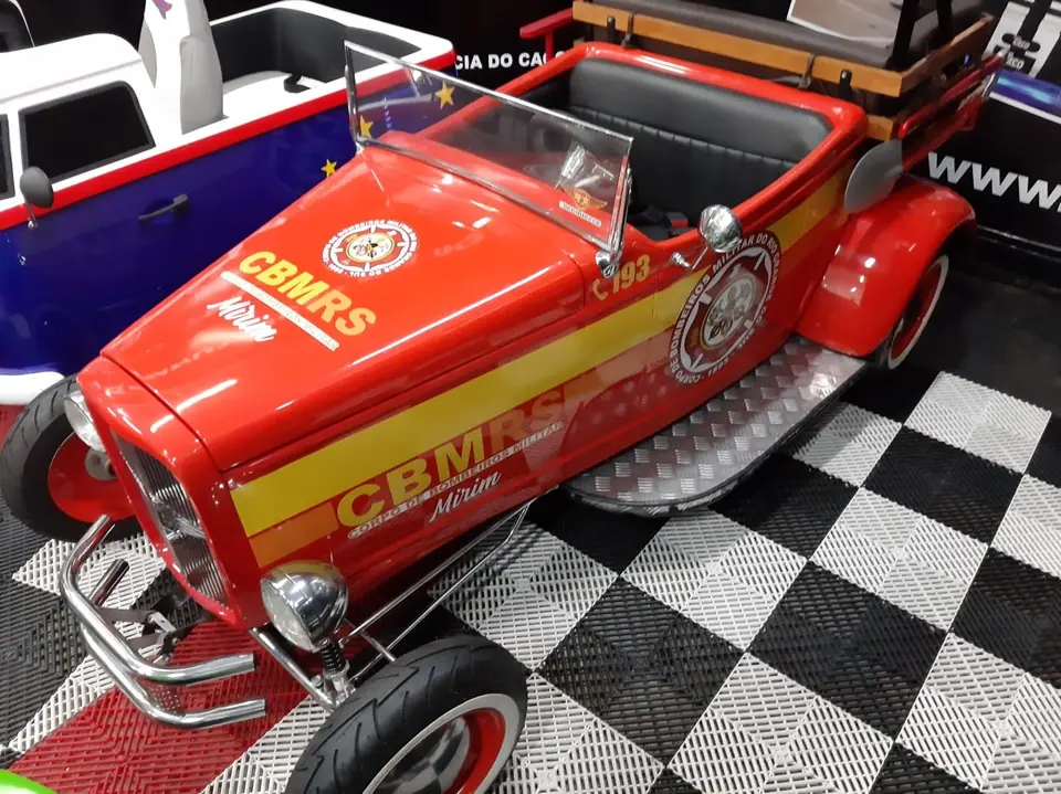 Mini carro de bombeiros vermelho e amarelo visto de frente