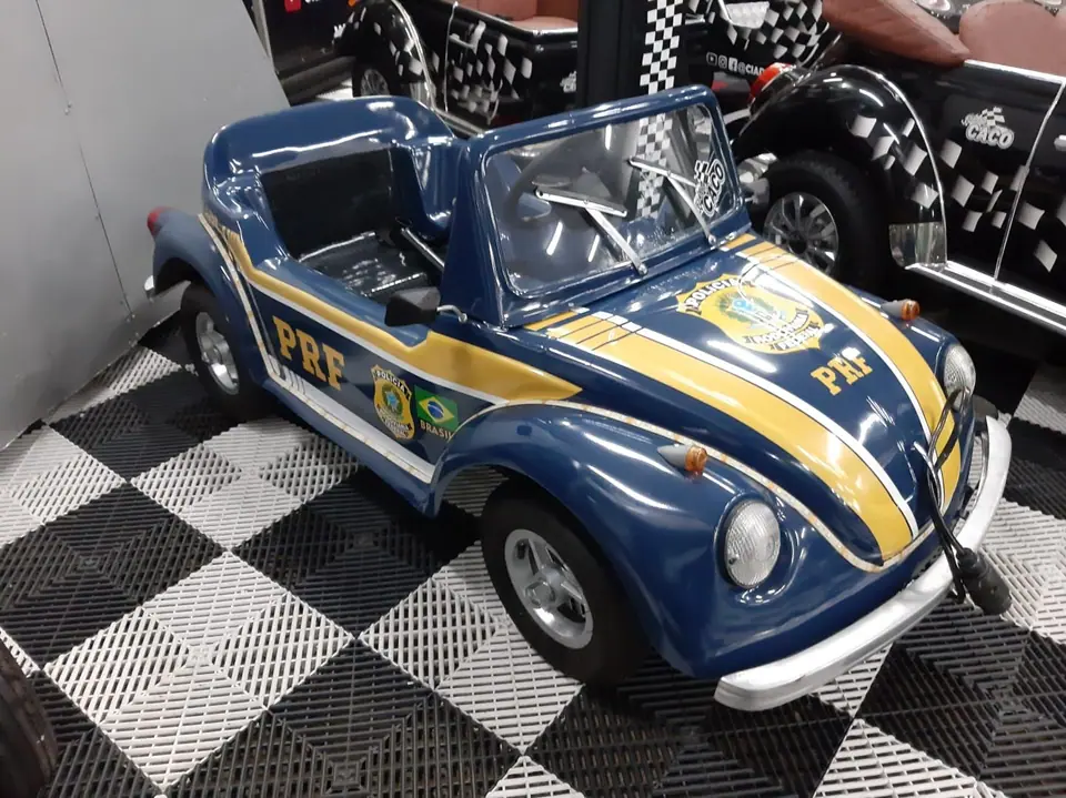 Mini Fusca azul da PRF sobre piso quadriculado