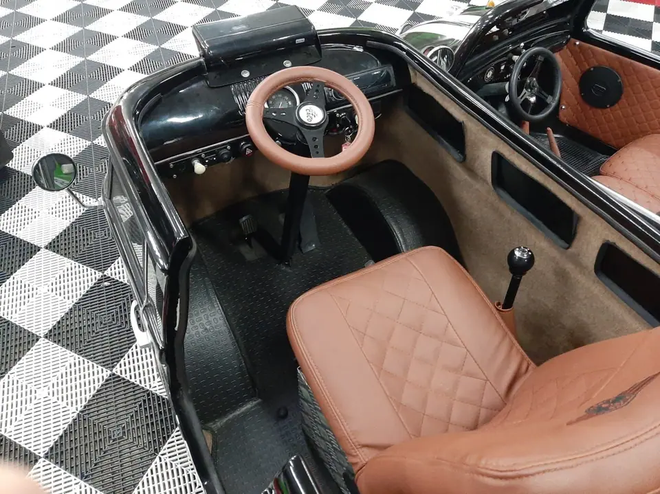 Interior da Mini Kombi com volante de madeira e bancos caramelo