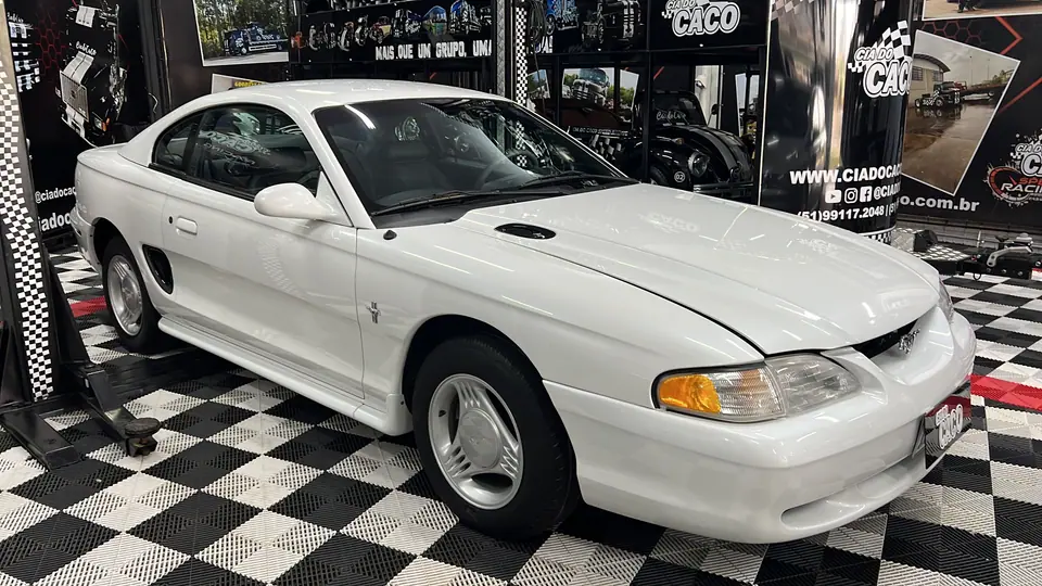 Ford Mustang branco exposto sobre piso quadriculado