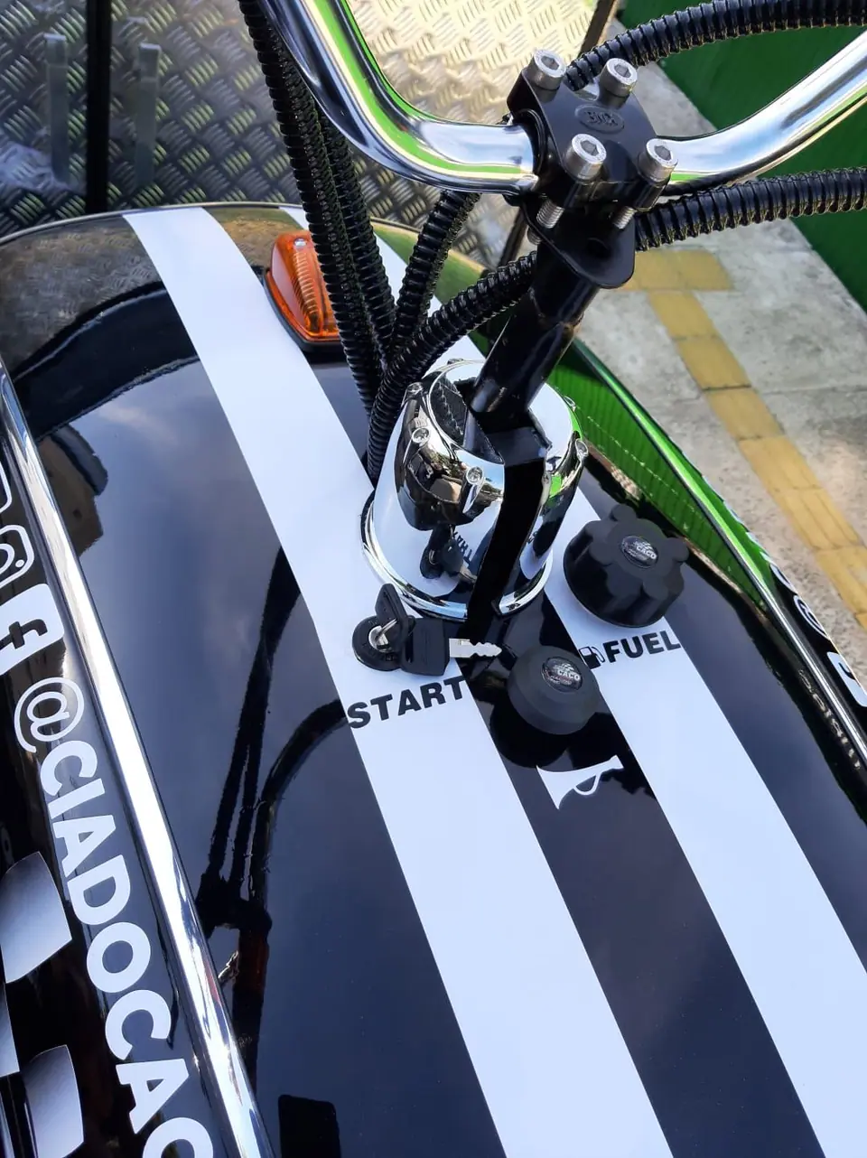 Detalhe do guidão e do tanque com a inscrição @ciadocaco
