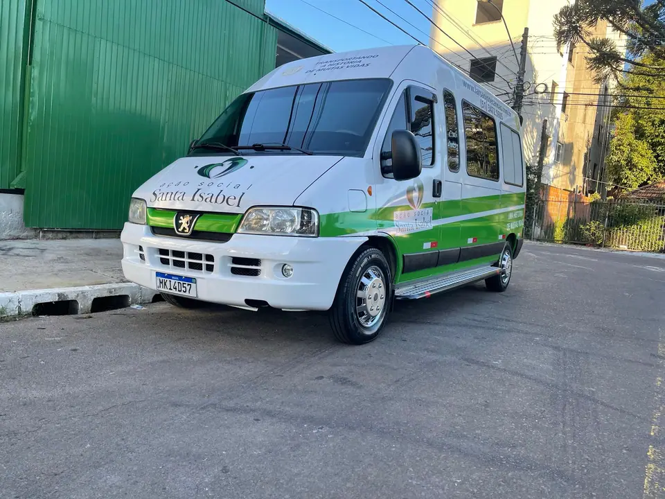 Van branca com identidade visual verde estacionada na rua