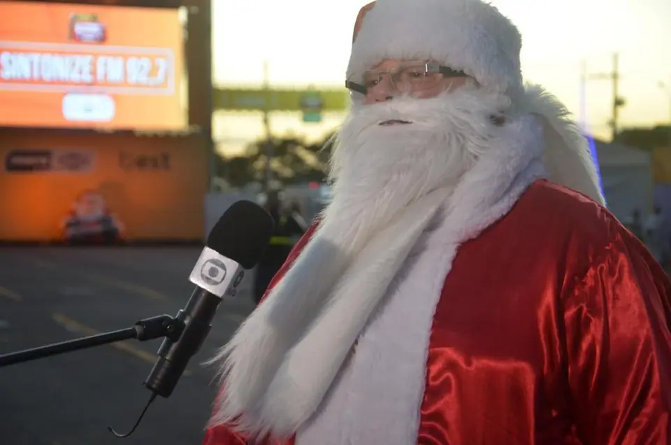 Papai Noel fala ao microfone de uma rádio
