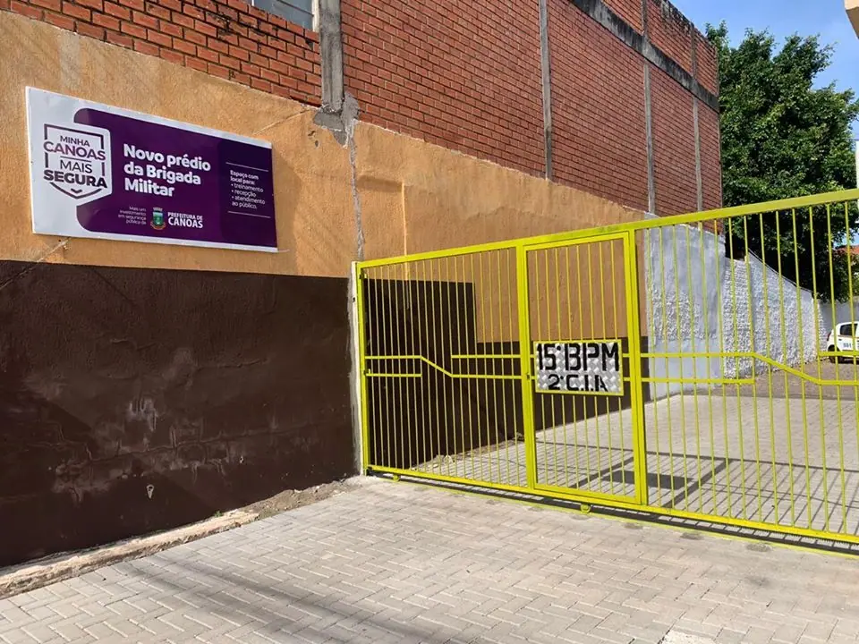 Fachada com placa de novo prédio da Brigada Militar e portão amarelo